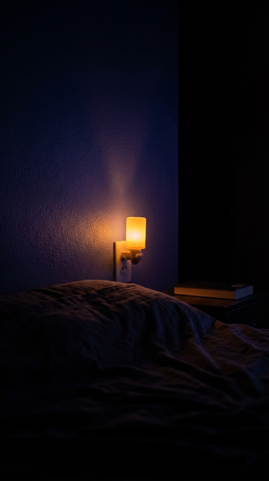 Soft amber night light glowing in a dark bedroom